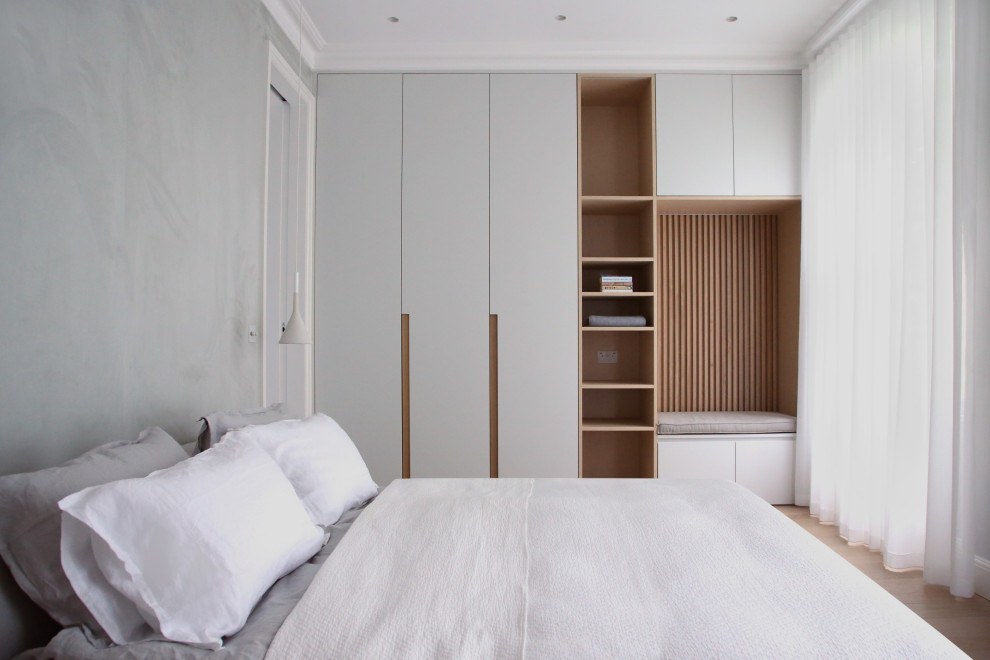 This is an example of a mid-sized contemporary master bedroom in London with grey walls and beige floor.