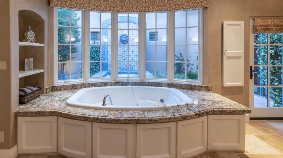 Large tuscan master drop-in bathtub photo in Phoenix with granite countertops