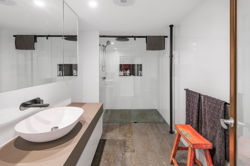 Design ideas for a mid-sized master bathroom in Brisbane with flat-panel cabinets, grey cabinets, an alcove shower, white tile, ceramic tile, white walls, concrete floors, a vessel sink, concrete benchtops, grey floor, a hinged shower door and white benchtops.