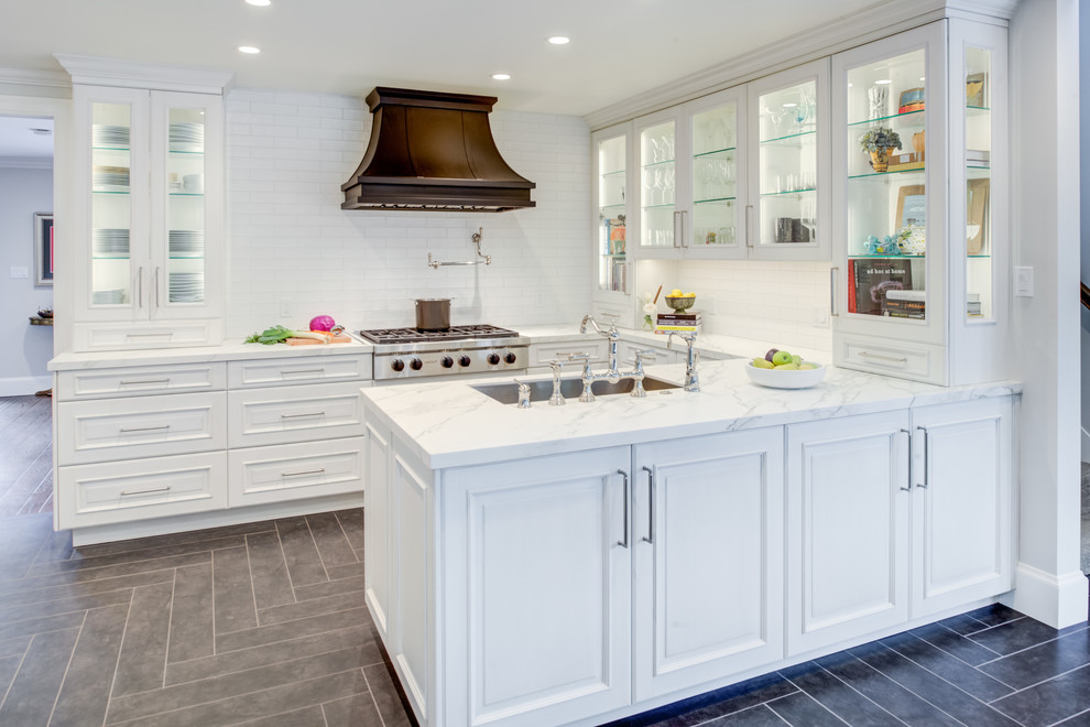 Inspiration for a transitional u-shaped kitchen in San Francisco with an undermount sink, raised-panel cabinets, white cabinets, white splashback, subway tile splashback, a peninsula, white benchtop, quartz benchtops, panelled appliances, grey floor and ceramic floors.