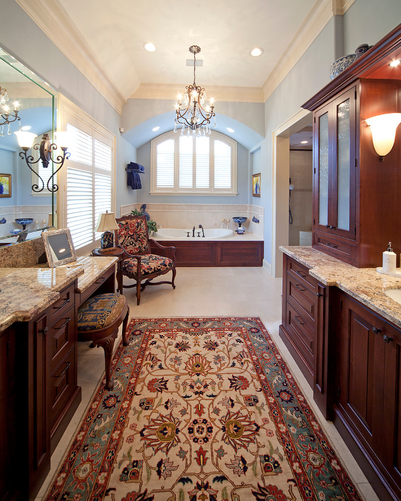 Inspiration for a large traditional master bathroom in Houston with an undermount sink, raised-panel cabinets, granite benchtops, a drop-in tub, brown cabinets, blue walls and white floor.