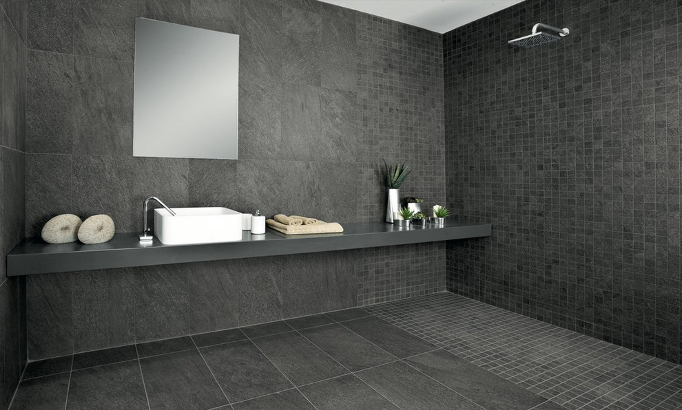 This is an example of a modern master bathroom in New York with a curbless shower, black tile, black walls, ceramic floors, a vessel sink and slate.