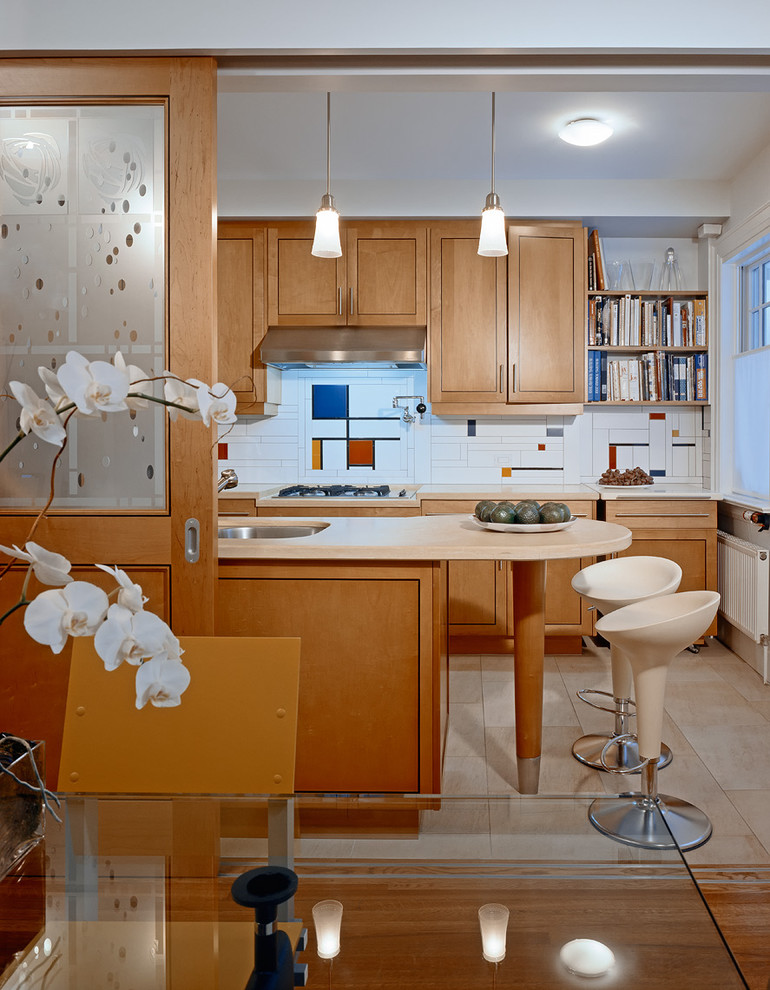 This is an example of a midcentury kitchen in Toronto with an undermount sink, shaker cabinets, medium wood cabinets and multi-coloured splashback.