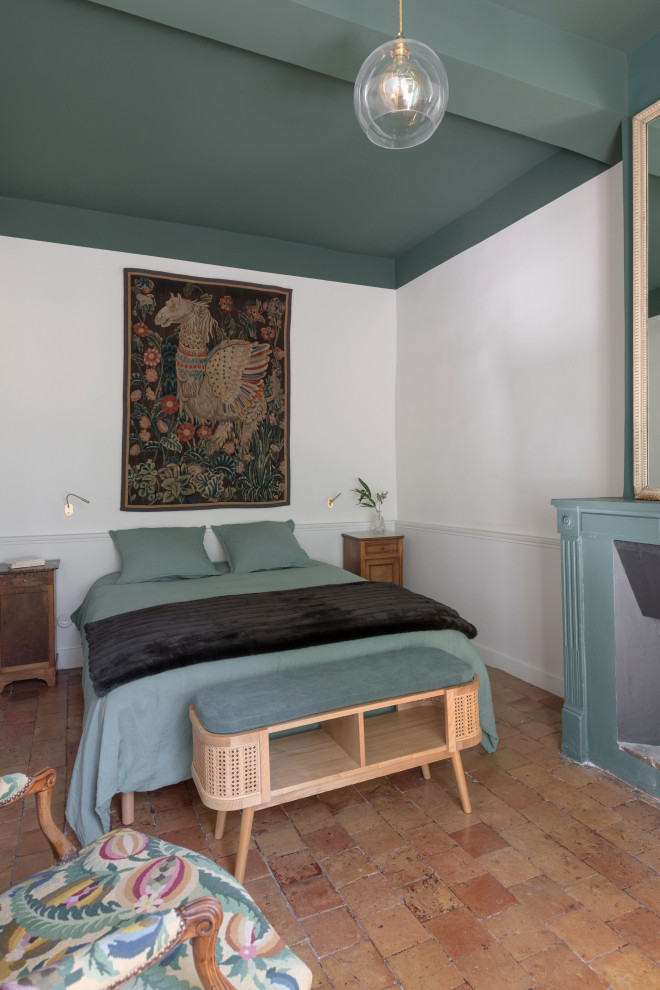 Idee per una camera degli ospiti tradizionale di medie dimensioni con pavimento in terracotta, camino classico e cornice del camino in intonaco