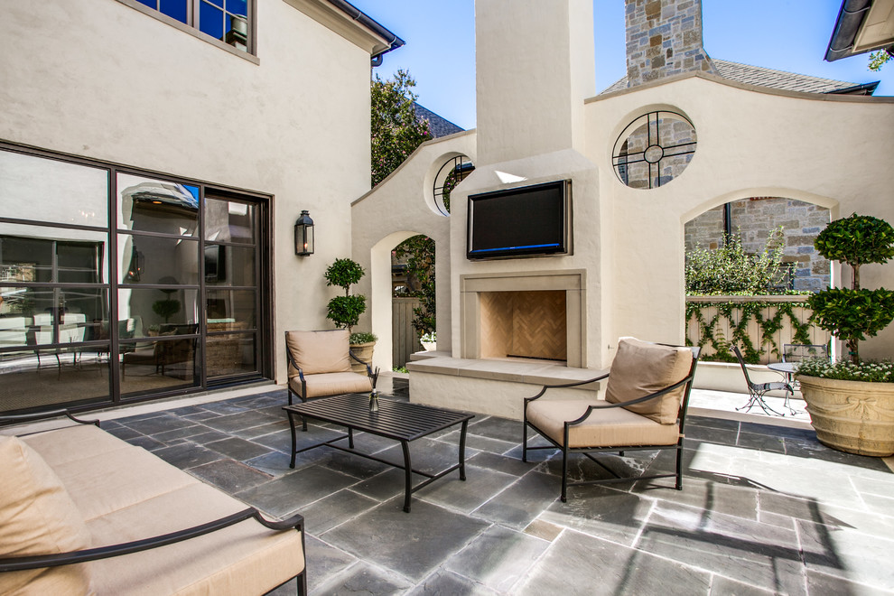 This is an example of a transitional patio in Dallas with a fire feature.