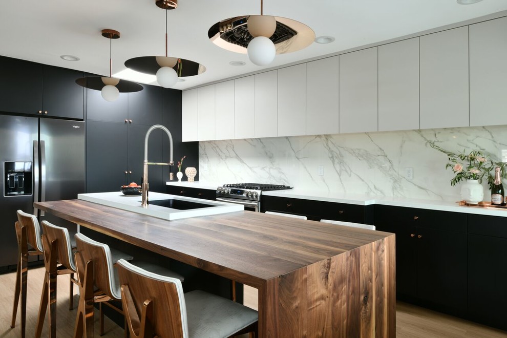 Design ideas for a contemporary kitchen in San Diego with a single-bowl sink, flat-panel cabinets, white splashback, stone slab splashback, stainless steel appliances, with island, white benchtop, medium hardwood floors and brown floor.