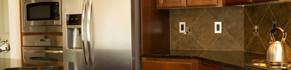 Example of a mid-sized transitional u-shaped enclosed kitchen design in Austin with shaker cabinets, dark wood cabinets, granite countertops, beige backsplash, stone tile backsplash, stainless steel appliances and a peninsula