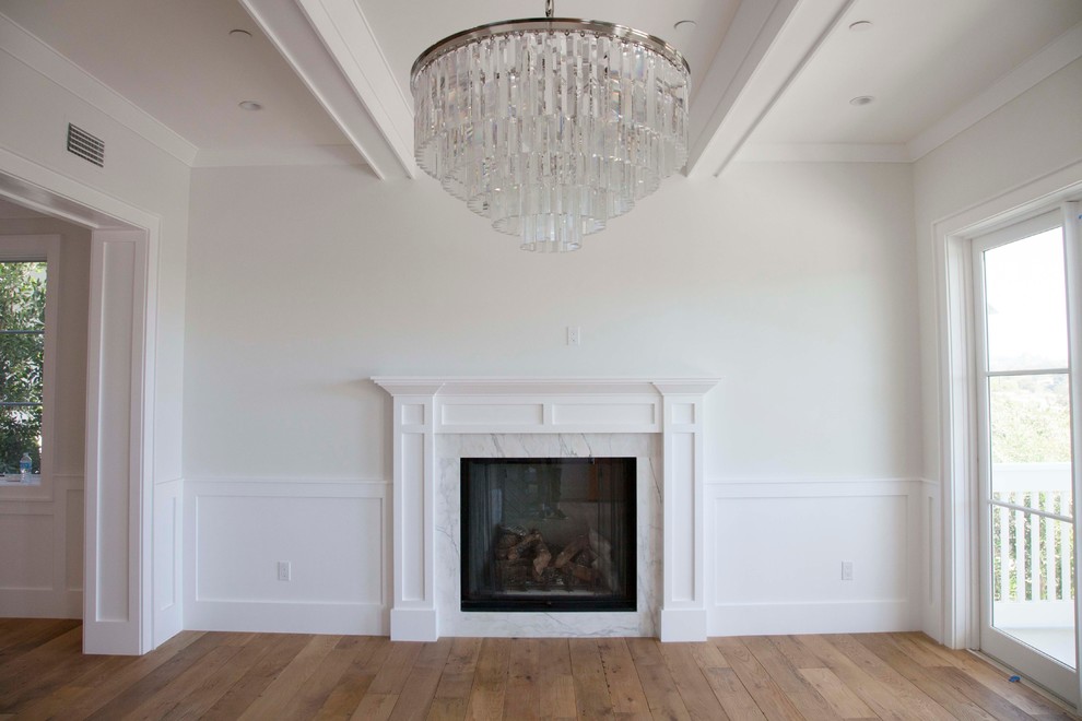 This is an example of a large beach style formal open concept living room in Los Angeles with white walls, medium hardwood floors, a standard fireplace and a stone fireplace surround.