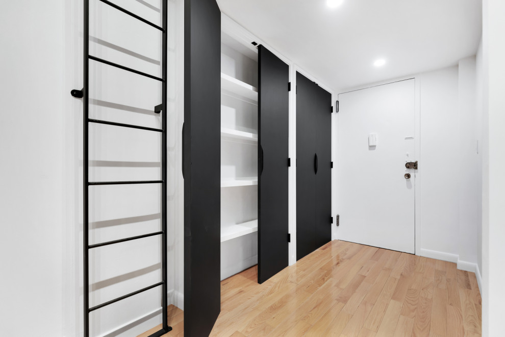 На фото: большой шкаф в нише унисекс в стиле модернизм с плоскими фасадами и черными фасадами с