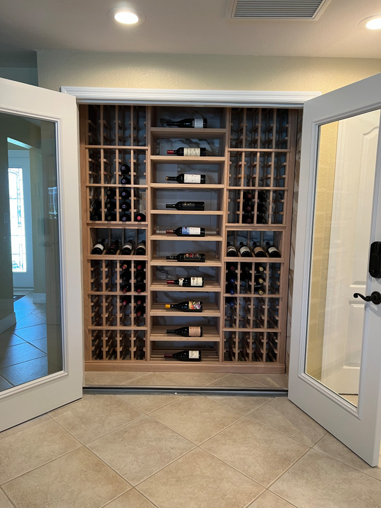 Wine cellar - small traditional porcelain tile and beige floor wine cellar idea in Tampa with display racks