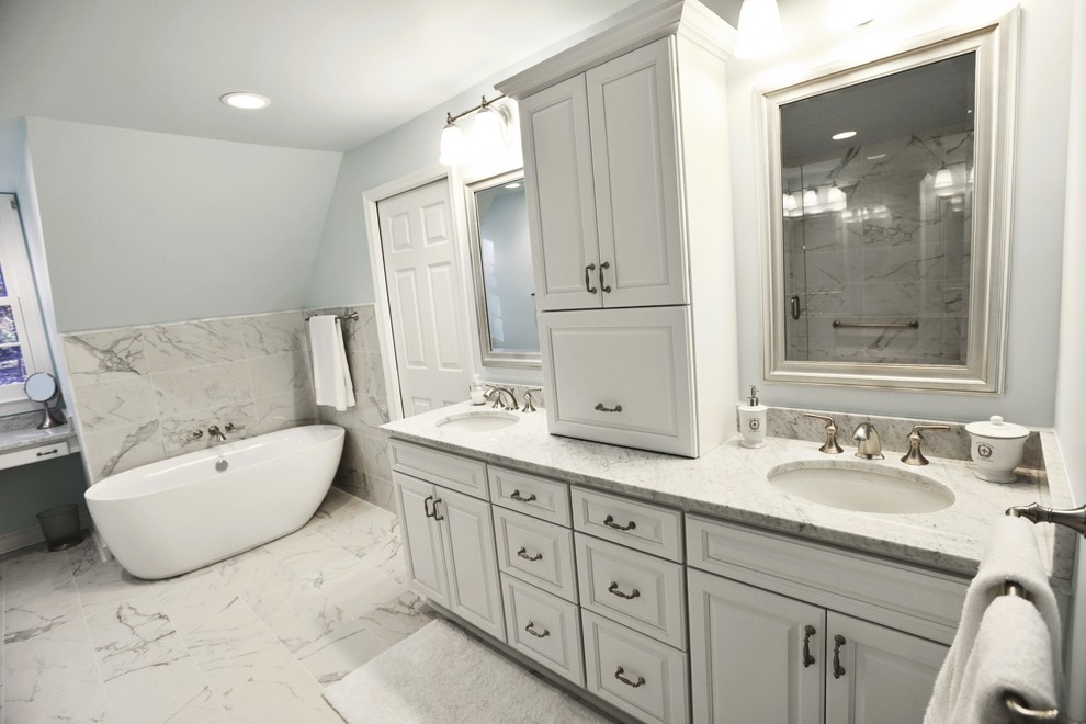 This is an example of a large modern master bathroom in Baltimore with raised-panel cabinets, white cabinets, a freestanding tub, a bidet, white tile, blue walls, marble floors and granite benchtops.
