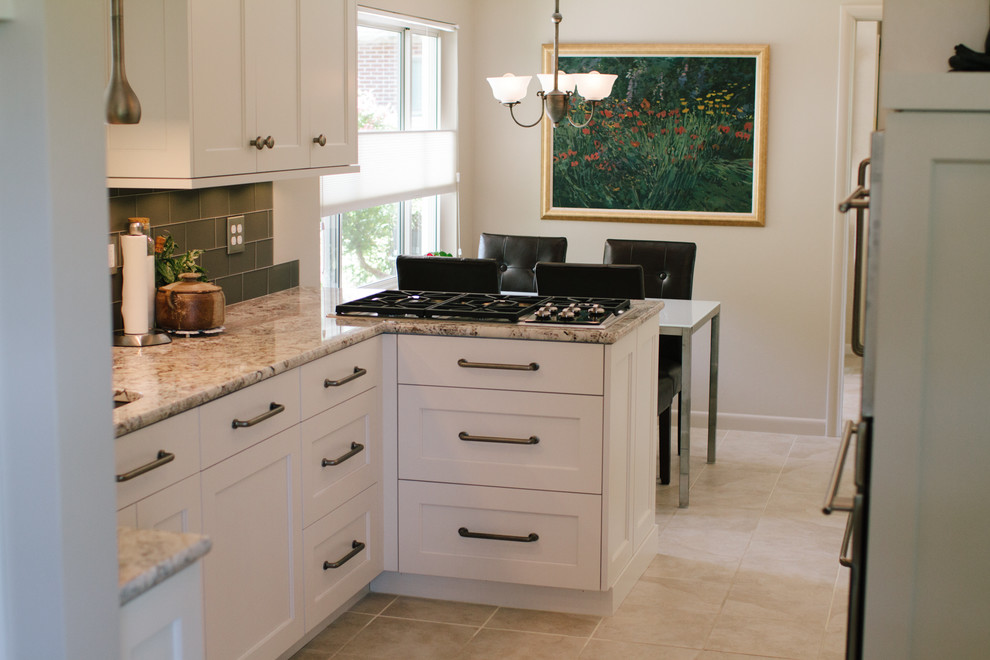 Small contemporary u-shaped open plan kitchen in Salt Lake City with an undermount sink, recessed-panel cabinets, white cabinets, granite benchtops, beige splashback, porcelain splashback, stainless steel appliances, ceramic floors and with island.