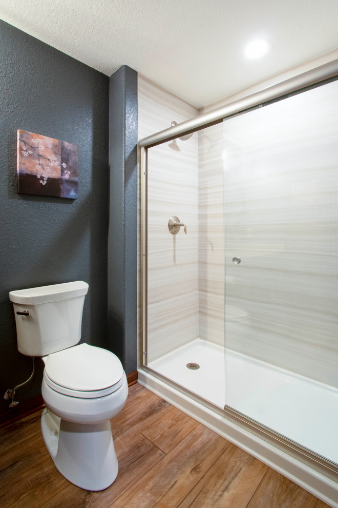 Cette photo montre une petite salle de bain chic avec un placard à porte shaker, des portes de placard marrons, WC séparés, un carrelage beige, des dalles de pierre, un mur bleu, un sol en vinyl, un lavabo encastré, un plan de toilette en quartz modifié, un sol beige, une cabine de douche à porte coulissante, un plan de toilette beige, meuble simple vasque et meuble-lavabo encastré.