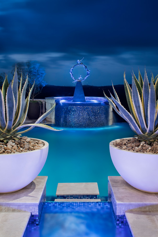 Example of a large transitional backyard infinity pool fountain design in Austin