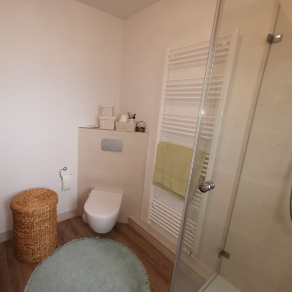 Duschbad With flächenbündigen Schrankfronten, weißen Schränken, Wandtoilette mit Spülkasten, beigen Fliesen, Steinfliesen, weißer Wandfarbe, Fliesen in Holzoptik, Wandwaschbecken, Glaswaschbecken/Glaswaschtisch, braunem Boden, offener Dusche, Duschbank, Einzelwaschbecken, schwebendem Waschtisch, Tapetendecke and Tapetenwänden in Hamburg