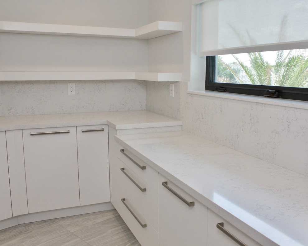 Large modern galley utility room in Miami with an utility sink, flat-panel cabinets, white cabinets, quartz benchtops, white walls, marble floors and a side-by-side washer and dryer.