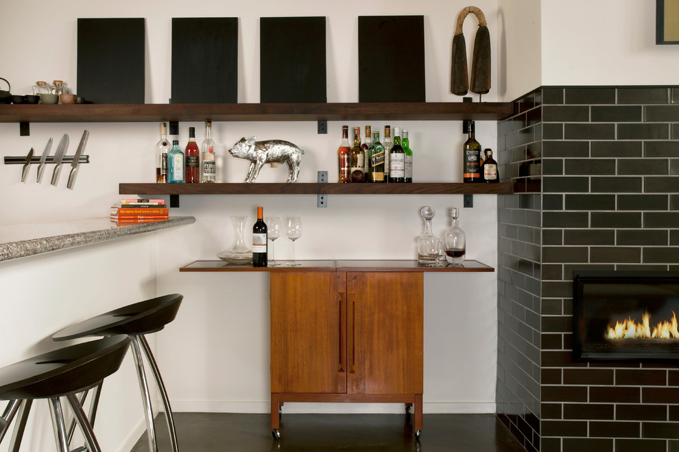 Photo of a small industrial bar cart in San Francisco with medium wood cabinets and black floor.