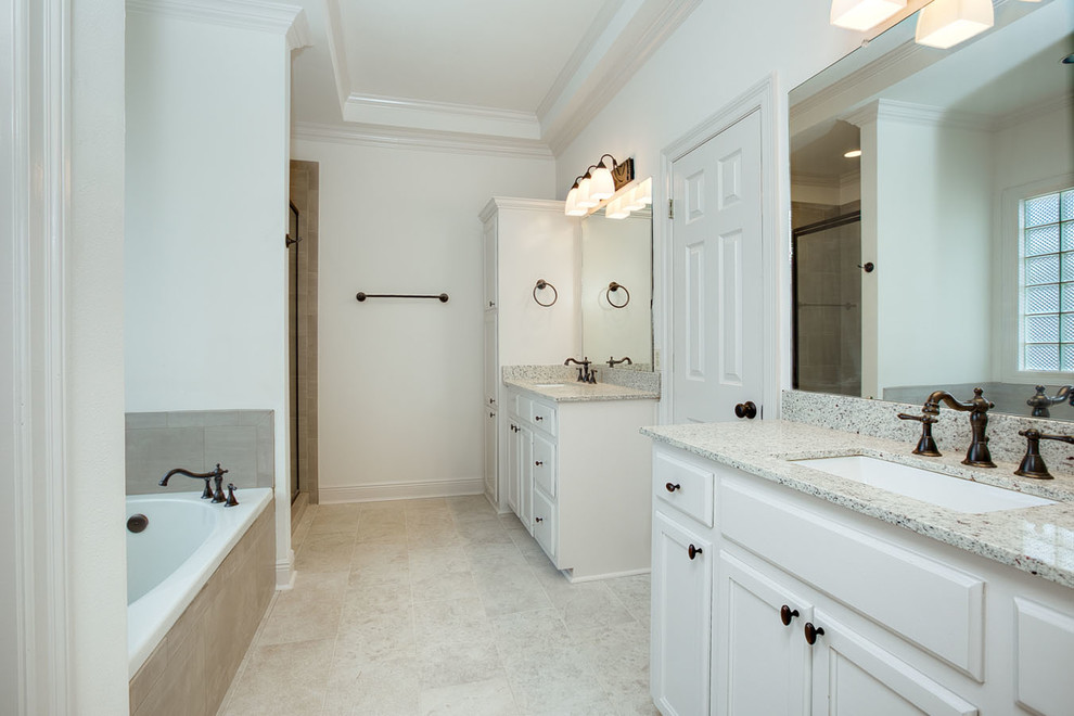 Exemple d'une douche en alcôve principale chic de taille moyenne avec un placard avec porte à panneau surélevé, des portes de placard blanches, une baignoire posée, WC à poser, un carrelage gris, des carreaux de porcelaine, un mur blanc, un sol en carrelage de porcelaine, un lavabo encastré, un plan de toilette en granite, un sol gris, une cabine de douche à porte battante et un plan de toilette blanc.