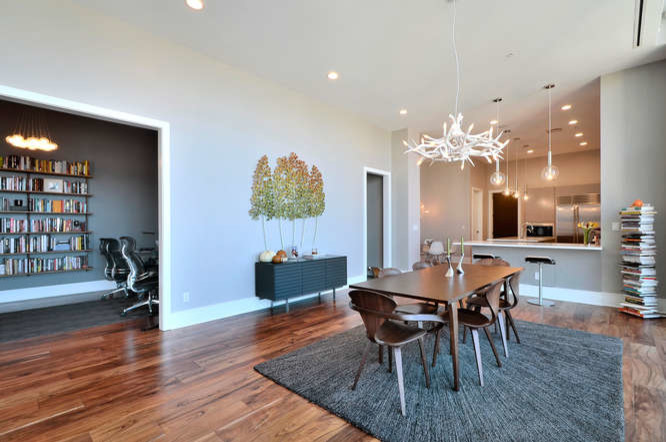 Photo of a large contemporary dining room in Austin with grey walls, medium hardwood floors, no fireplace and brown floor.