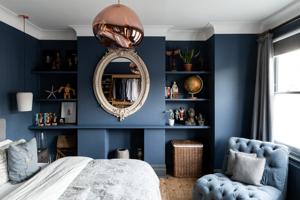 Bild på ett funkis sovrum, med blå väggar, mellanmörkt trägolv och en standard öppen spis
