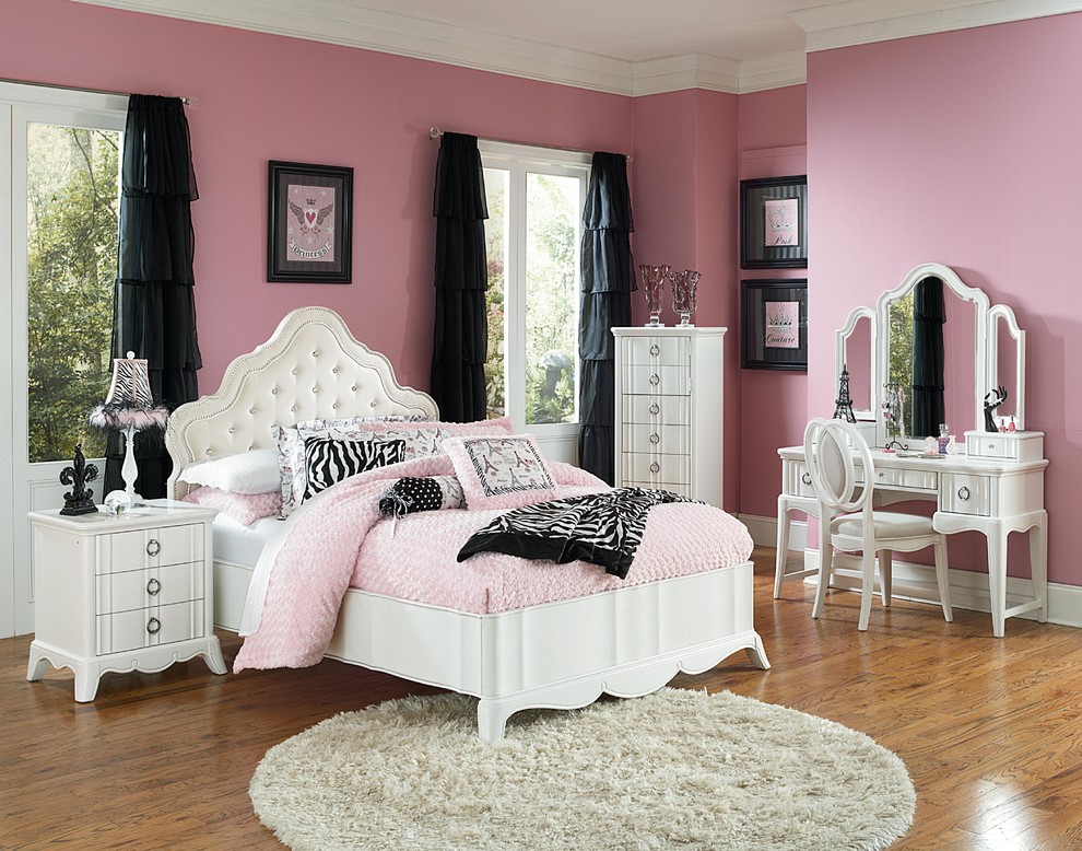Inspiration for a midcentury kids' room for girls in Indianapolis with pink walls and light hardwood floors.