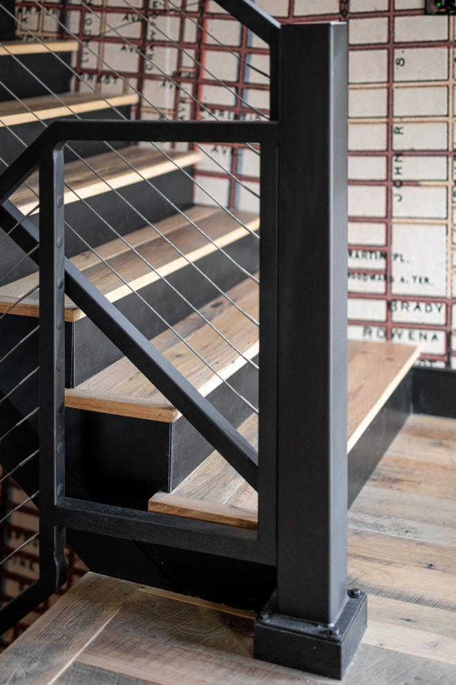 Diseño de escalera en L contemporánea sin contrahuella con escalones de madera, barandilla de metal y papel pintado
