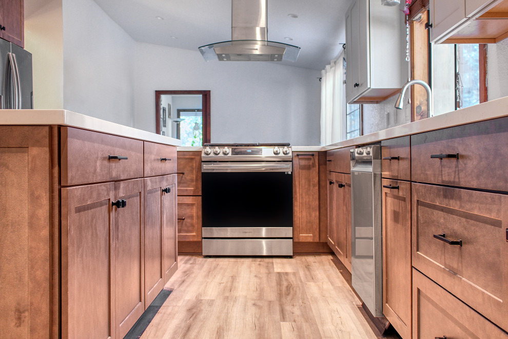 Foto på ett stort lantligt vit kök och matrum, med en undermonterad diskho, skåp i shakerstil, skåp i mellenmörkt trä, bänkskiva i kvarts, vitt stänkskydd, rostfria vitvaror, vinylgolv, en köksö och brunt golv