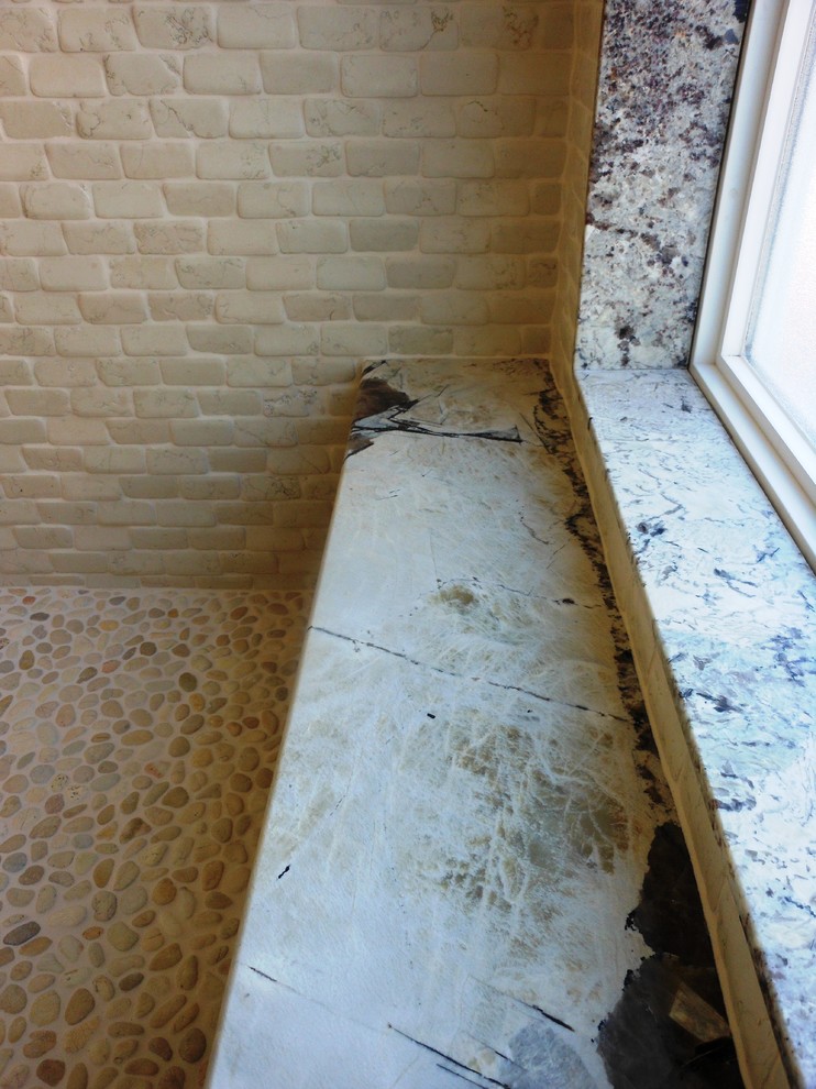 Example of a large mountain style master beige tile and stone tile pebble tile floor walk-in shower design with granite countertops
