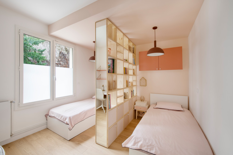 Immagine di una cameretta per bambini da 4 a 10 anni design con pareti bianche, parquet chiaro e pavimento beige