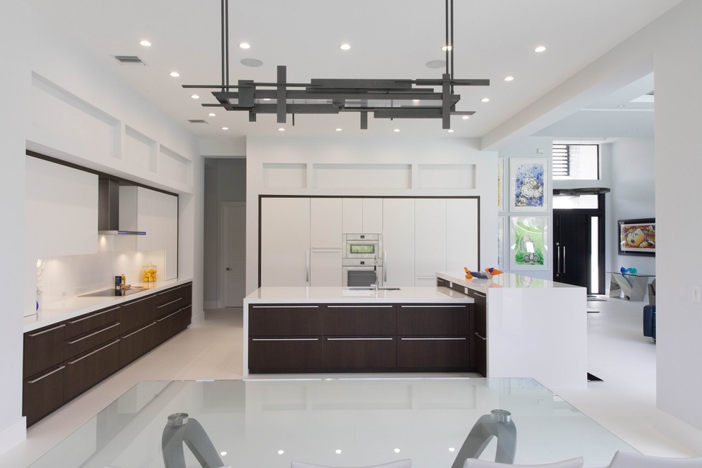 Inspiration for a large contemporary l-shaped open plan kitchen in Other with an undermount sink, flat-panel cabinets, white cabinets, quartz benchtops, white splashback, glass sheet splashback, panelled appliances, porcelain floors, with island, white floor and white benchtop.