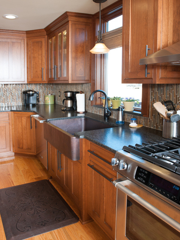 Mid-sized transitional l-shaped medium tone wood floor eat-in kitchen photo in Orange County with a farmhouse sink, shaker cabinets, medium tone wood cabinets, granite countertops, multicolored backsplash, matchstick tile backsplash, stainless steel appliances and an island