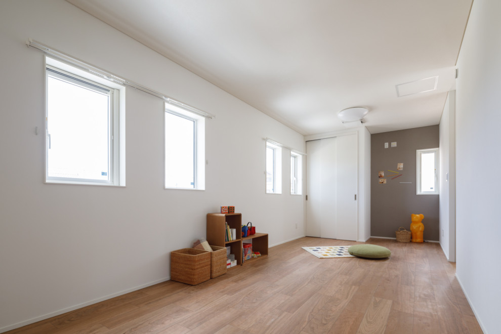 Example of a danish gender-neutral plywood floor, wallpaper ceiling and wallpaper childrens' room design in Other