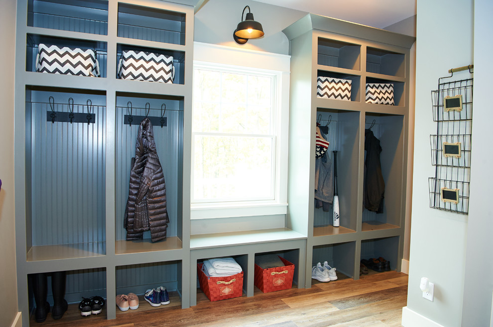 This is an example of a large country gender-neutral walk-in wardrobe in Indianapolis with open cabinets, grey cabinets, vinyl floors and brown floor.