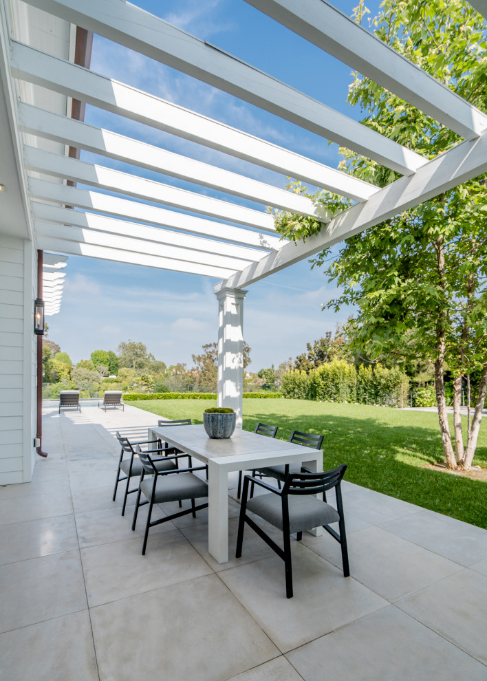 This is an example of a transitional patio in Los Angeles with a pergola.
