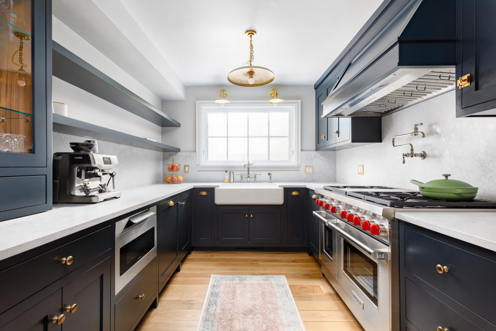 Inspiration for a mid-sized transitional u-shaped medium tone wood floor and beige floor eat-in kitchen remodel in Toronto with a farmhouse sink, beaded inset cabinets, blue cabinets, quartz countertops, beige backsplash, quartz backsplash, stainless steel appliances, no island and beige countertops