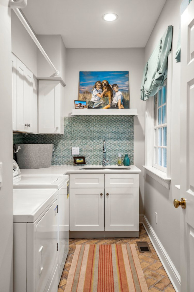 Inspiration for a traditional laundry room in Boston with an undermount sink, blue splashback, mosaic tile splashback, brick floors, a side-by-side washer and dryer, brown floor and white benchtop.