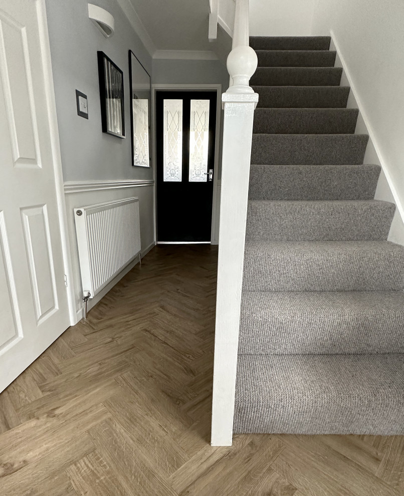 Foto de escalera recta minimalista pequeña con escalones enmoquetados, contrahuellas enmoquetadas y barandilla de madera