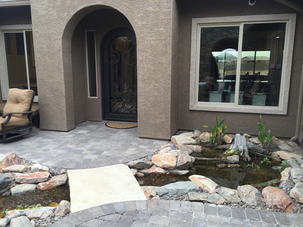 Inspiration for a large transitional courtyard partial sun garden in Phoenix with with pond.
