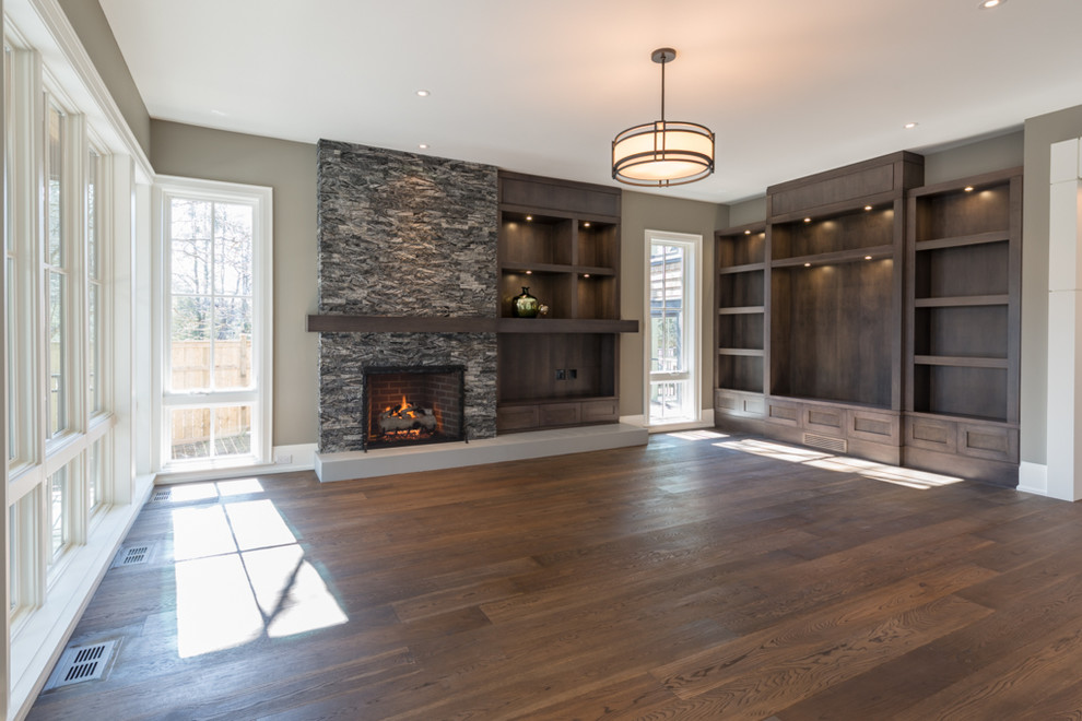 Design ideas for a large contemporary open concept family room in Toronto with grey walls, medium hardwood floors, a standard fireplace, a stone fireplace surround and a built-in media wall.
