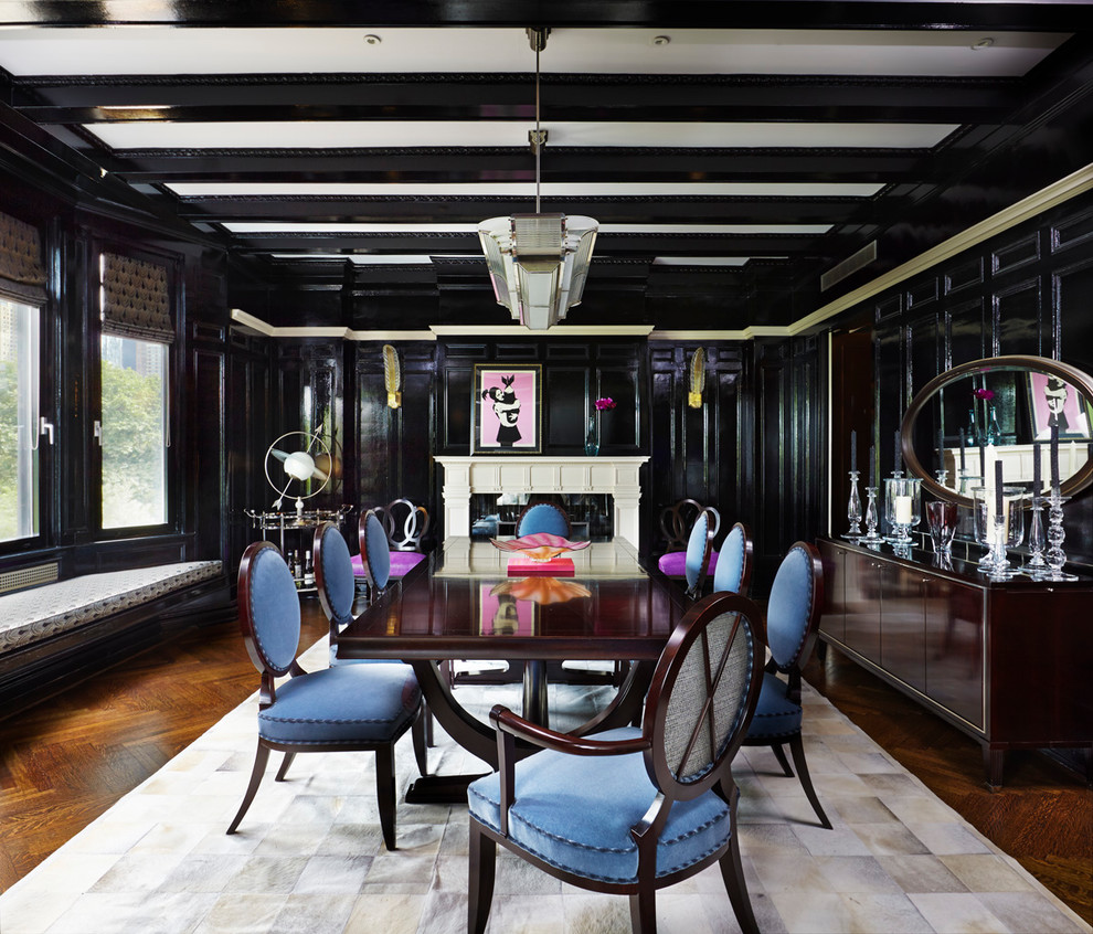 This is an example of a contemporary separate dining room in New York with black walls, dark hardwood floors and a standard fireplace.
