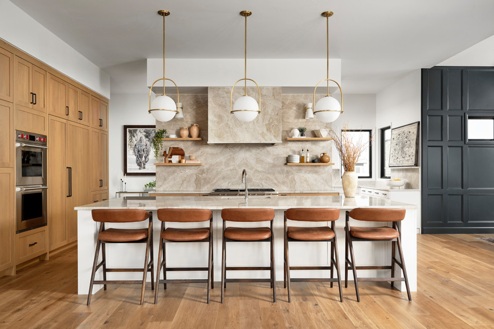 Eat-in kitchen - mid-sized transitional medium tone wood floor and brown floor eat-in kitchen idea in Denver with an undermount sink, shaker cabinets, medium tone wood cabinets, marble countertops, beige backsplash, marble backsplash, stainless steel appliances, an island and beige countertops