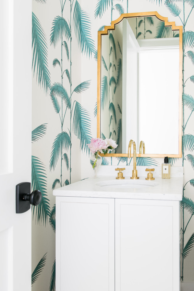 Photo of a beach style powder room in Charleston with shaker cabinets, white cabinets, multi-coloured walls, an undermount sink and white benchtops.