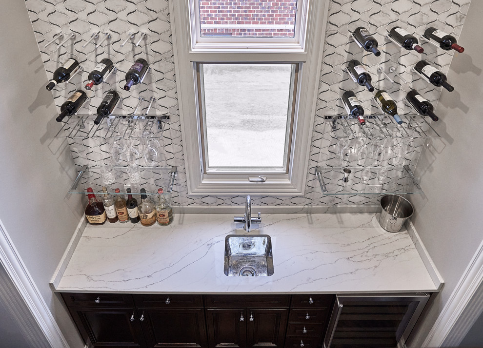 Exempel på en mellanstor klassisk vita linjär vitt hemmabar med vask, med en undermonterad diskho, luckor med infälld panel, skåp i mörkt trä, bänkskiva i kvarts, vitt stänkskydd, stänkskydd i marmor, mörkt trägolv och brunt golv