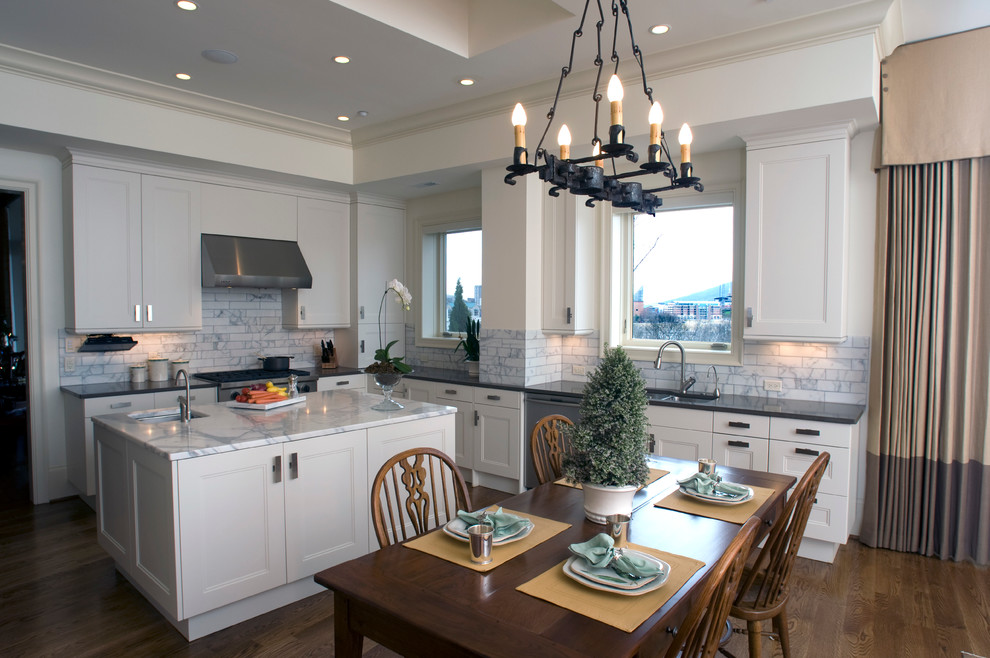 Inspiration for a large transitional u-shaped dark wood floor eat-in kitchen remodel with an undermount sink, recessed-panel cabinets, white cabinets, quartz countertops, white backsplash, subway tile backsplash, stainless steel appliances and an island