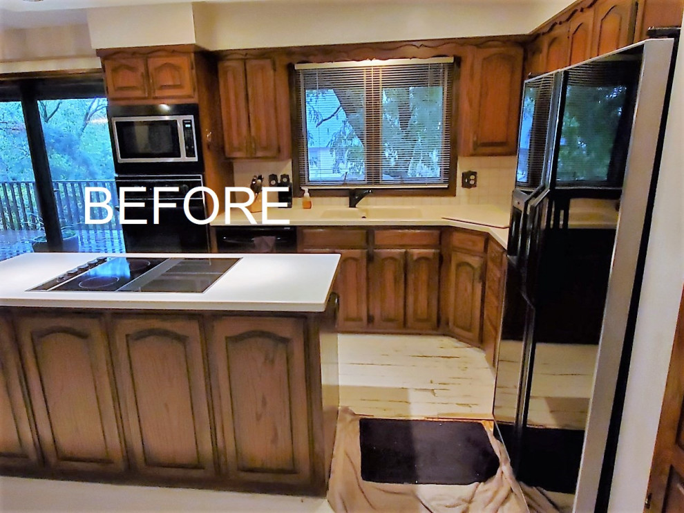 Open concept kitchen - mid-sized transitional l-shaped light wood floor open concept kitchen idea with a double-bowl sink, raised-panel cabinets, dark wood cabinets, solid surface countertops, white backsplash, ceramic backsplash, black appliances, an island and white countertops