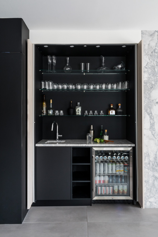 Design ideas for a contemporary single-wall wet bar in Boston with an undermount sink, flat-panel cabinets, black cabinets, grey floor and white benchtop.