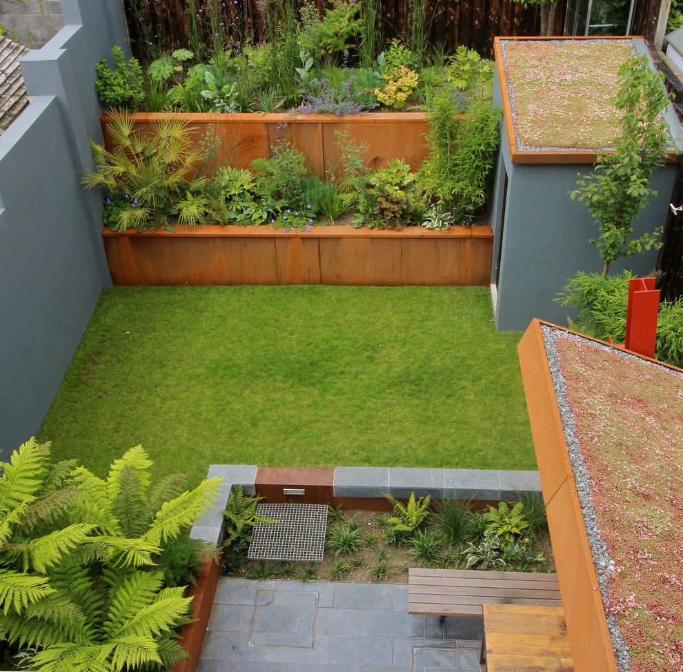 Photo of a contemporary backyard partial sun garden in Dublin with natural stone pavers.