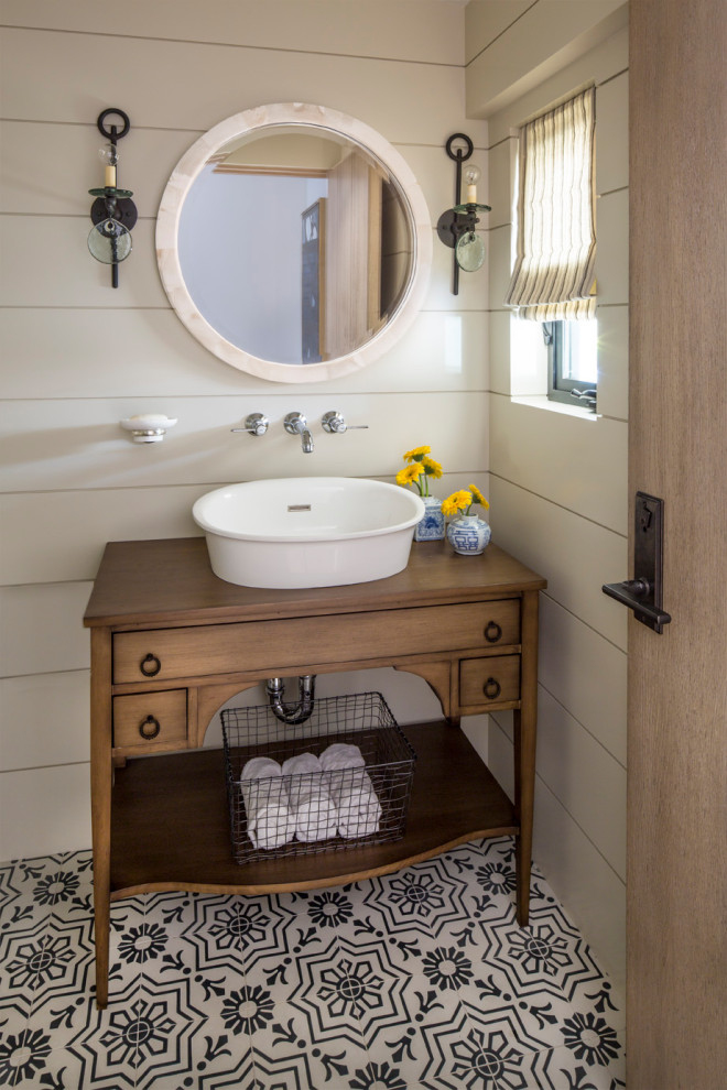 Mid-sized transitional powder room in Los Angeles with furniture-like cabinets, medium wood cabinets, white walls, a vessel sink, wood benchtops, multi-coloured floor, beige benchtops, a freestanding vanity and planked wall panelling.