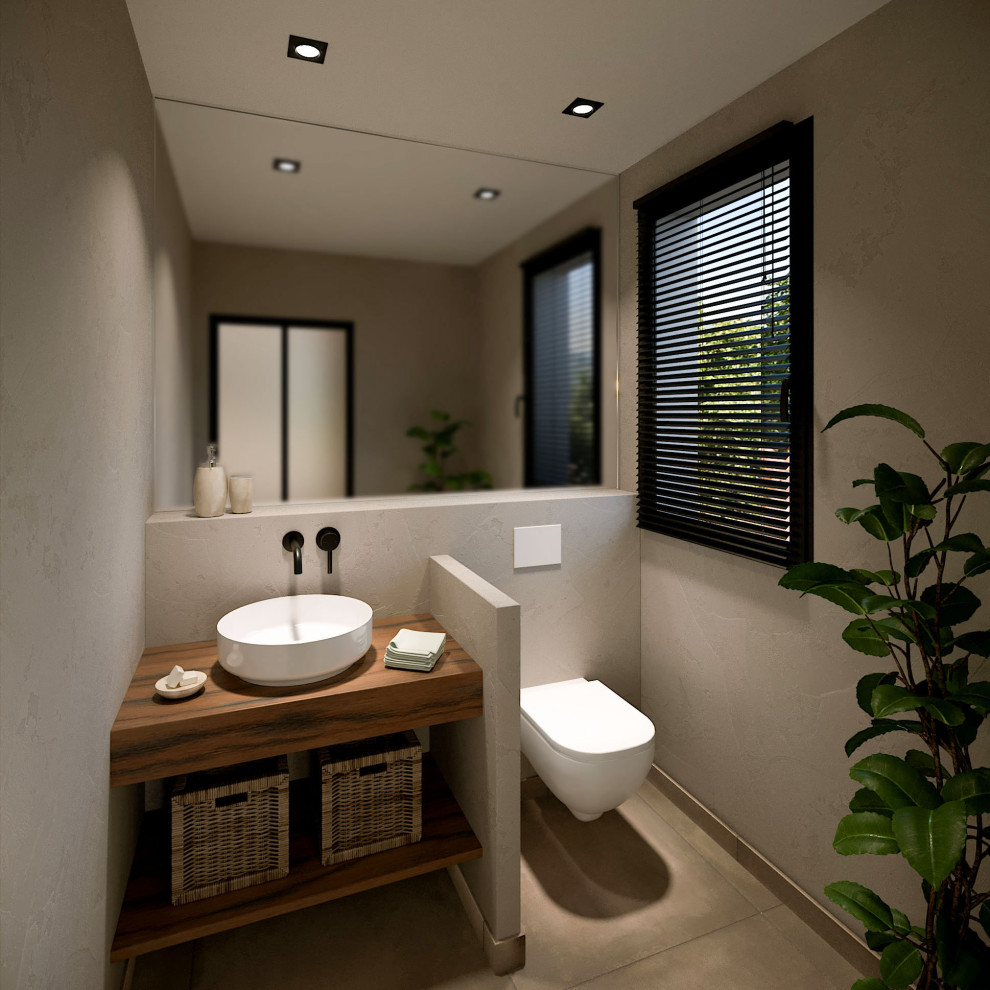 Kleine Mediterrane Gästetoilette mit Wandtoilette, beiger Wandfarbe, Keramikboden, Einbauwaschbecken, Waschtisch aus Holz, beigem Boden und brauner Waschtischplatte in Nizza