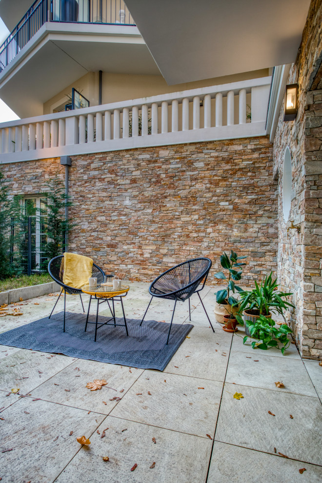 Esempio di un patio o portico tropicale di medie dimensioni e dietro casa con un giardino in vaso